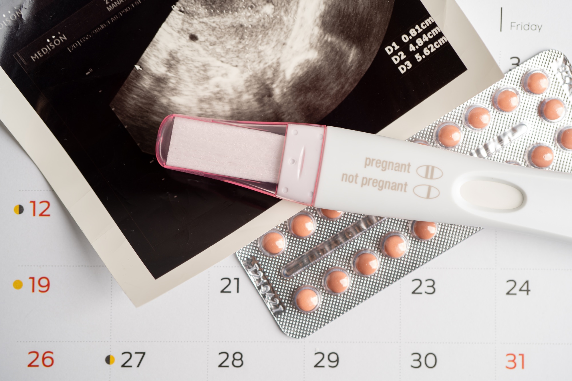 Pregnancy test and birth control pills with ultrasound scan of baby uterus, contraception health.
