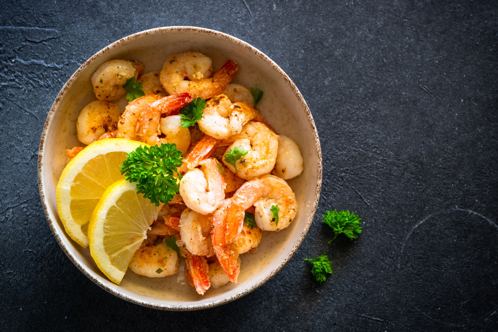 Frying shrimps with lemon in the bawl.